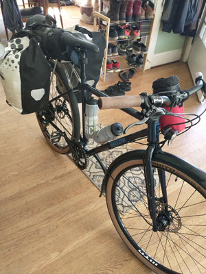 A black Breezer Doppler loaded with two water bottles and two panniers